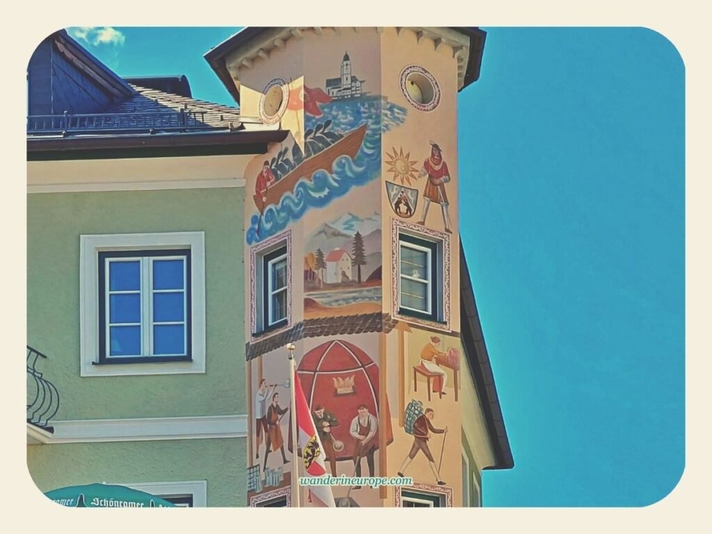 7 Attractions to See and Experience When Visiting St. Gilgen 7 Murals on the upper part of a corner tower in Mozartplatz in St. Gilgen, Salzburg, Austria