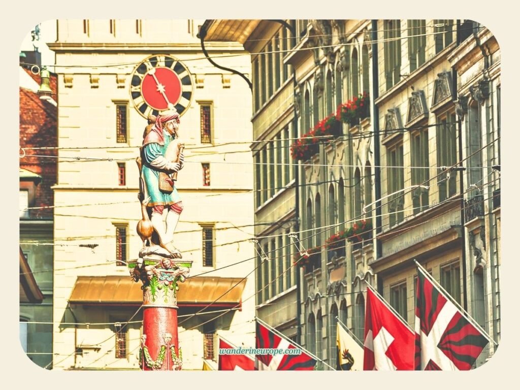 One Day In Bern Itinerary (Visit Landmarks & Scenic Spots) 9 Pfeiferbrunnen in Spitalgasse with Käfigturm on the backdrop in Bern, Switzerland