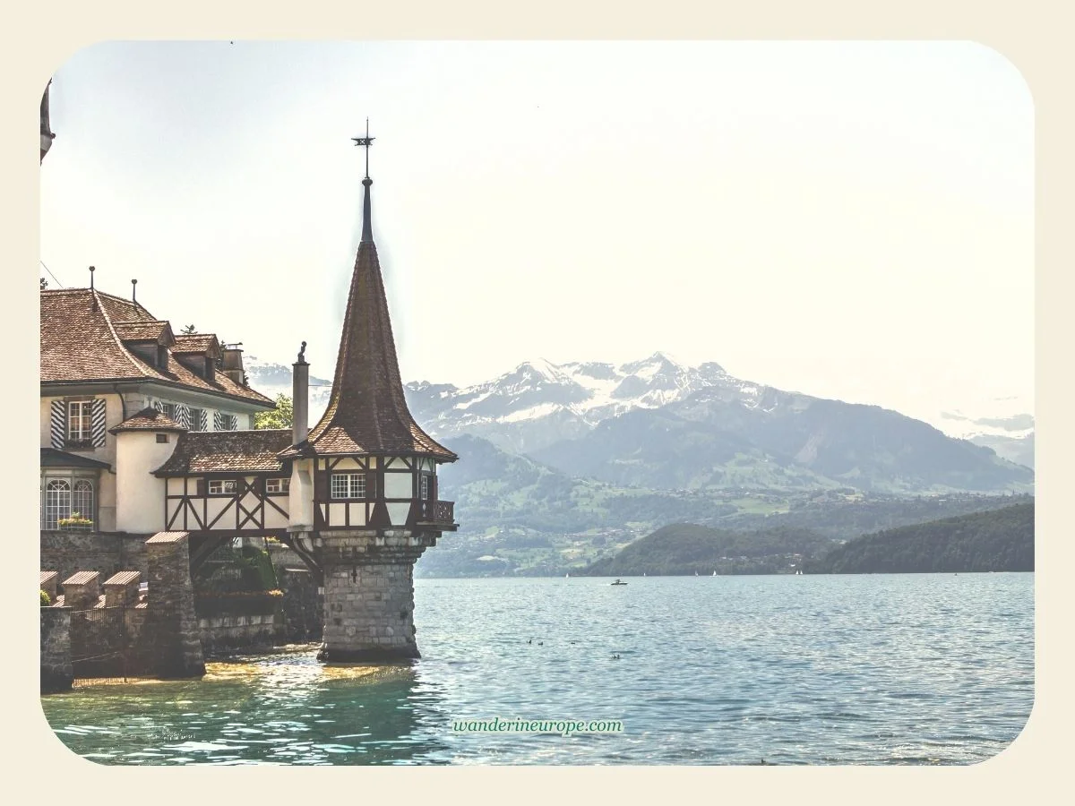 The snowy peaks of Bernese Oberland behind Oberhofen Castle in Thun, Switzerland