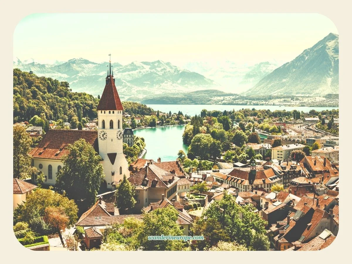 One Day Lake Thun Itinerary Sightseeing + Visiting Castles 11 Thun Old Town, Lake Thun, and the Bernese Alps in the backdrop. Shot taken at The Castle’s Tower in Thun, Switzerland