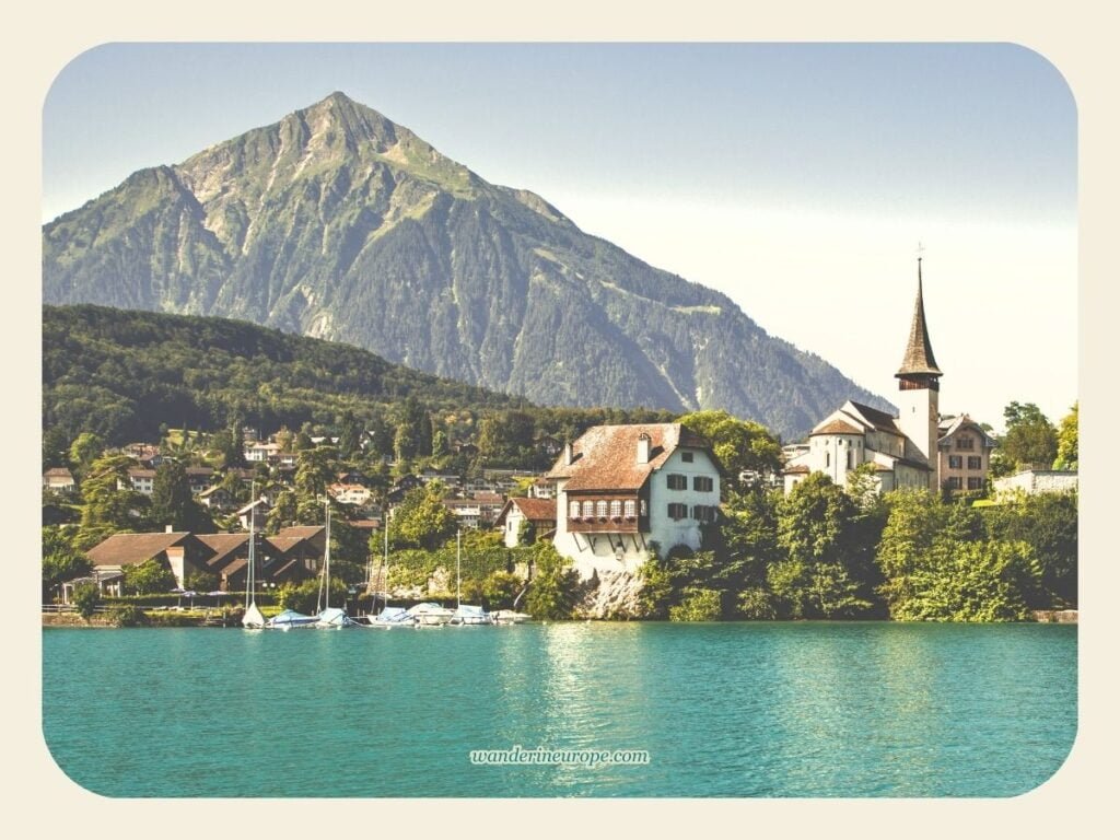 One Day Lake Thun Itinerary Sightseeing + Visiting Castles 25 View of Mount Niesen and Spiez from the boat approaching the harbor in Lake Thun, Switzerland