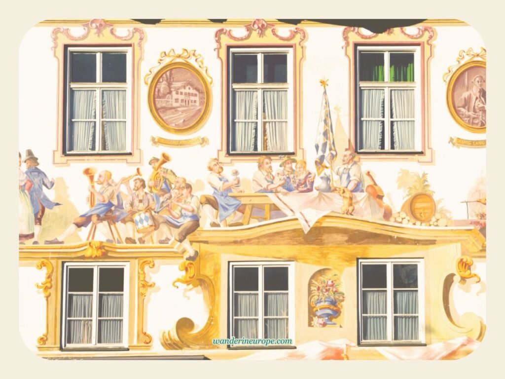 Lüftlmalerei in Oberammergau: The Fusion of Art and Culture 11 A festive scene of a Bavarian celebration depicted by a Lüftlmalerei in Oberammergau, Germany